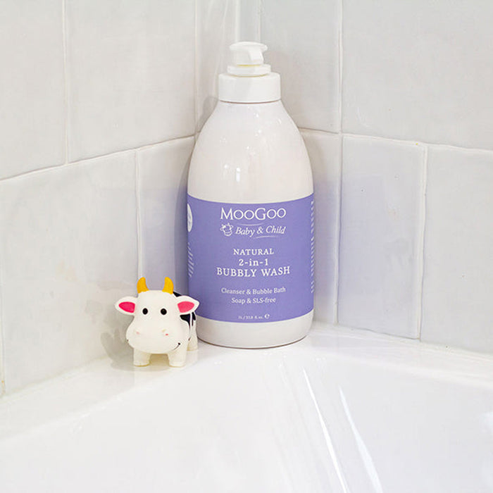 Moogoo Baby & Child bubbly wash bottle on a tiled bathroom shelf with a cow-shaped toy.