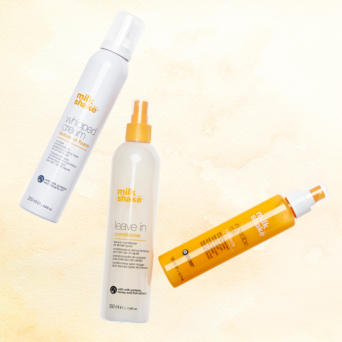 Three bottles of milk_shake hair care products on a light yellow background