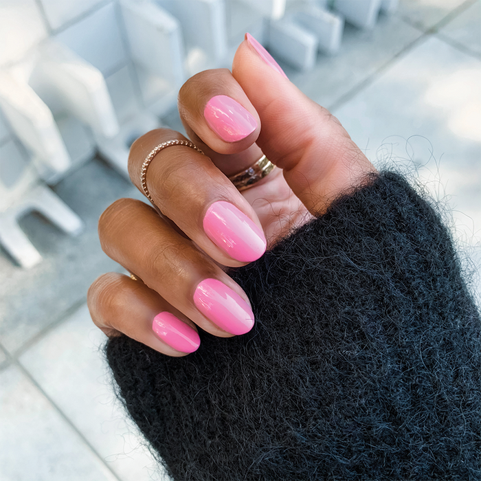 Hand with nails painted in JM gel polish showing a glossy pinky lavender manicure by Olive and June