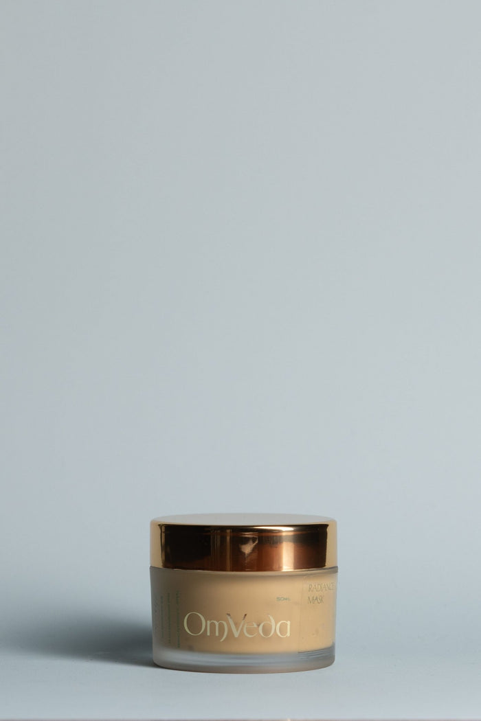 OmVeda Radiance Mask gold cosmetic jar with gold lid