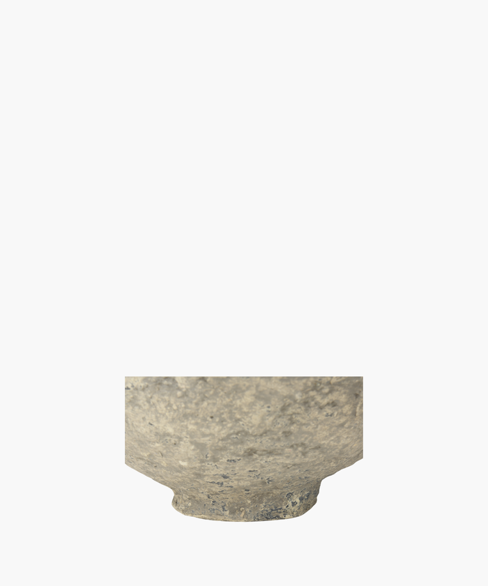 A detailed picture of a rustic, paper mache bowl highlighting the textured surface, showcasing shades of gray and subtle patches of darker tones. The bowl exudes an ancient, historical feel.