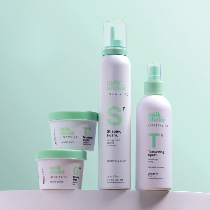 Set of hair care products from milk_shake with green and white packaging on a light green background.