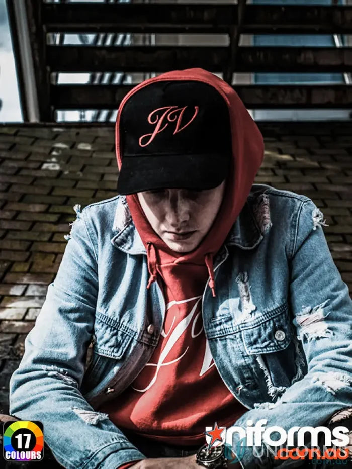 Person in red hoodie and denim jacket showcasing MOQ25 Embroidered Caps made of heavy brushed cotton