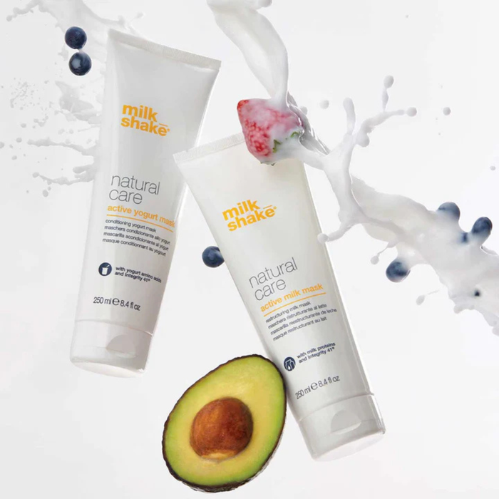 Two tubes of milk_shake natural care products with an avocado and blueberries on a white background
