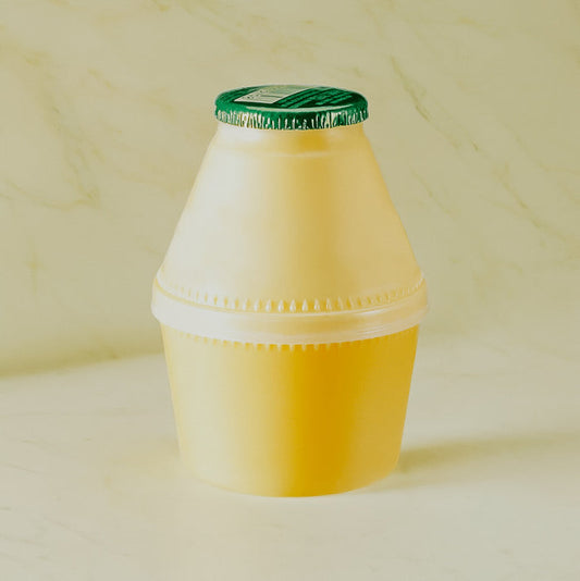 A yellow container with a green lid, resembling a bottle of banana milk.