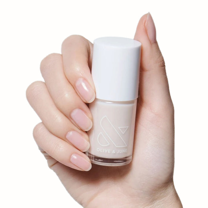 Hand holding a bottle of BEB sheer white gel polish showing a natural, fresh manicure look
