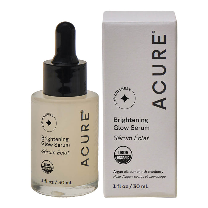 Dropper bottle of serum next to a cardboard box on a white background.