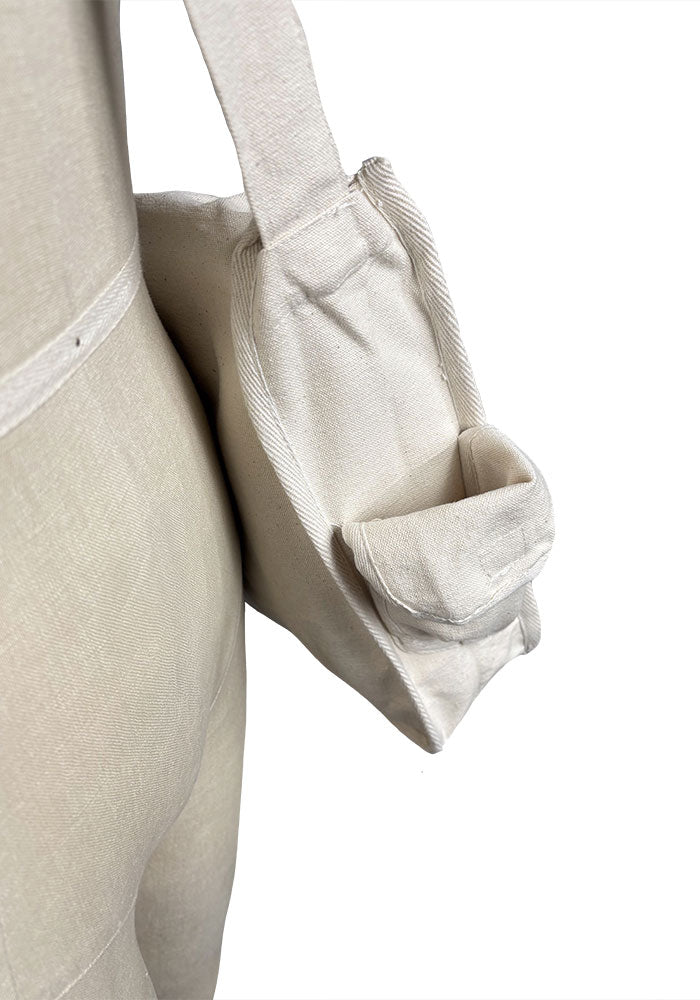 Close up of canvas bag displayed on a mannequin against a plain background.