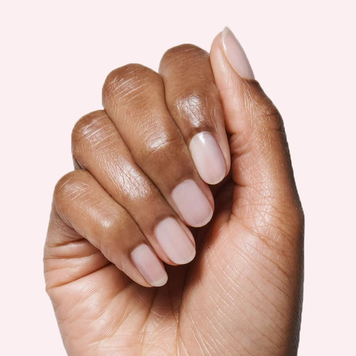 Hand with nails painted in CCT sheer neutral pastel pink gel polish for a soft and natural manicure look