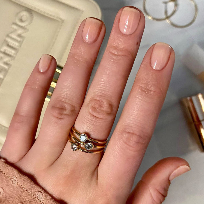Hand with nails polished in CCT sheer neutral pastel pink for an elegant and natural gel polish manicure look
