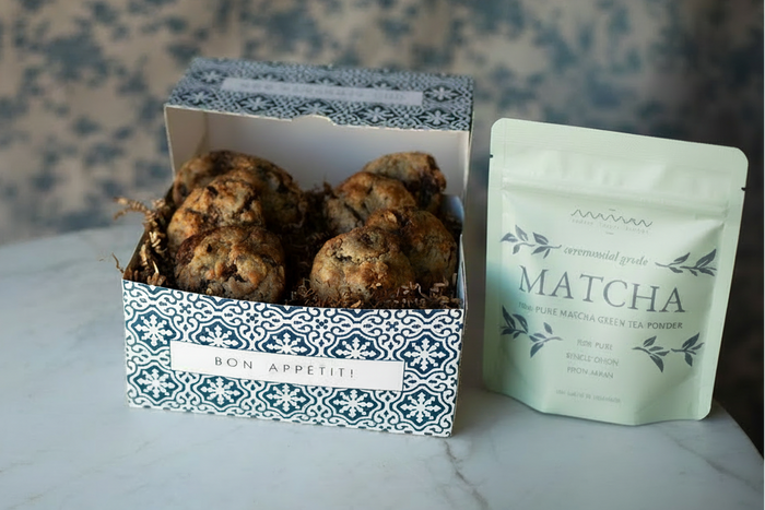 light green maman matcha powder pouch placed next to a maman cookie gift box.