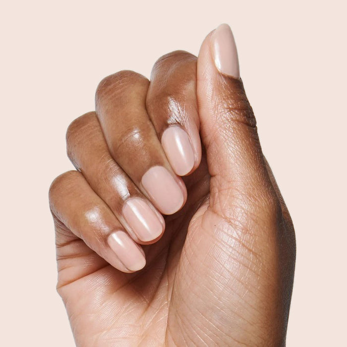 Hand with nails polished in CHM sheer tan for a flattering and natural gel polish manicure look