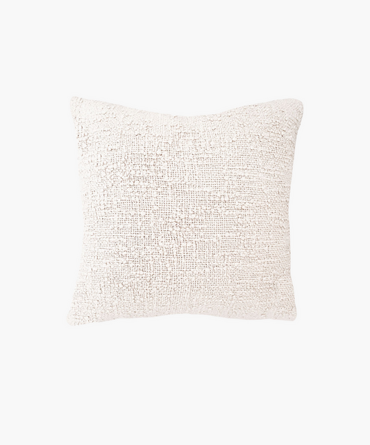 A textured square pillow in a soft ivory color, featuring a woven boucle pattern. The design gives a cozy, inviting feel, ideal for home decor. | Wildwood Home Co.