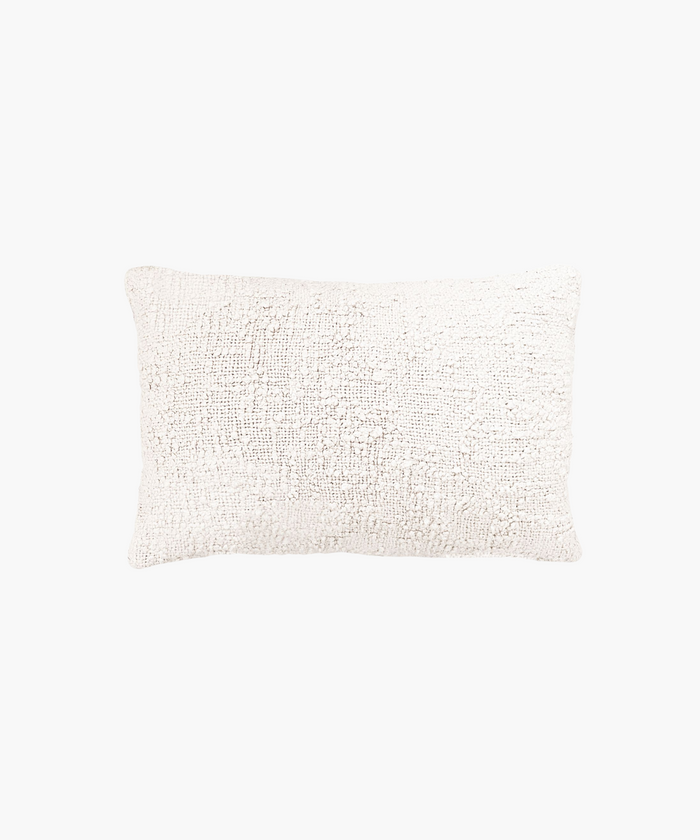 A textured rectangular lumbar pillow in a soft ivory color, featuring a woven boucle pattern. The design gives a cozy, inviting feel, ideal for home decor. | Wildwood Home Co.