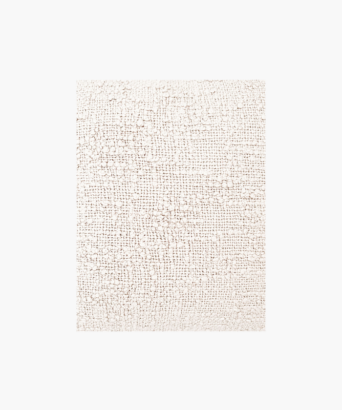 A detailed picture of a pillow in a soft ivory color, featuring a textured woven boucle pattern. The design gives a cozy, inviting feel, ideal for home decor.