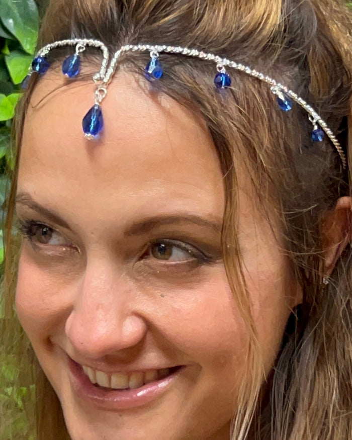 model wearing silver wire crown headpiece with blue crystal drops
