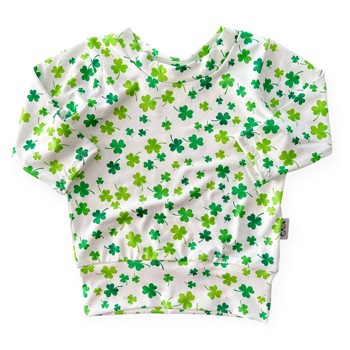 Handmade white lounge top with green shamrock print for babies and toddlers. Perfect for St. Patrick's Day festivities and comfortable everyday wear. Sizes NB to 4T.