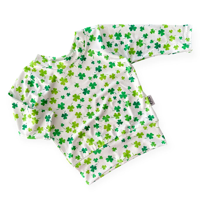 Handmade white lounge top with green shamrock print for babies and toddlers. Perfect for St. Patrick's Day festivities and comfortable everyday wear. Sizes NB to 4T.