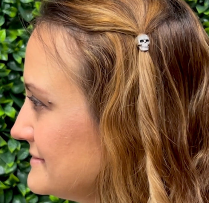 Silver skull hair bead worn in side braid, side view