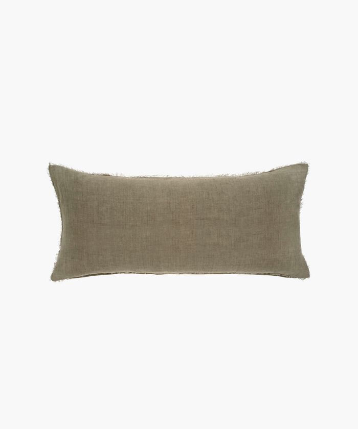 A rectangular lumbar, beige pillow with a subtle textured fabric and frayed edges. The pillow has a minimalist, cozy appearance, suitable for neutral decor. | Wildwood Home Co.