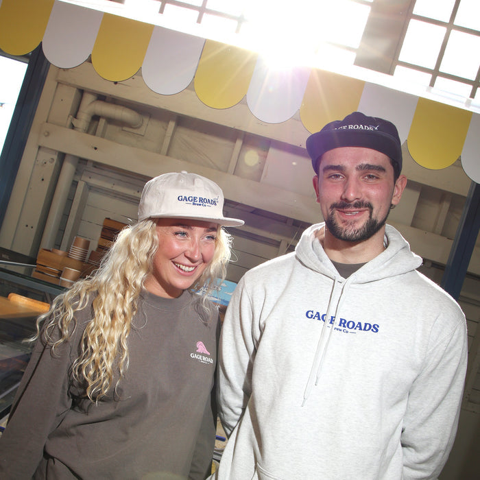 Two people wearing 'Gage Roads' branded hoodies standing in front of an ice cream stall