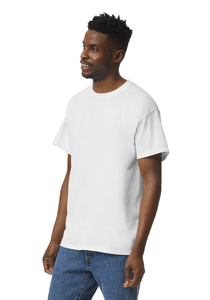 Quarter turn view of a man wearing a white Gildan 5.3oz. Cotton Short Sleeve T-shirt and blue jeans on a white background.