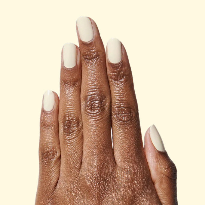 Hand showing nails painted in JLR pastel sunny yellow gel polish for a bright and fresh manicure by Olive and June