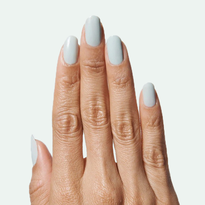 Hand with nails painted in soft muted sage green KMC gel polish for a clean, long-lasting at-home manicure look