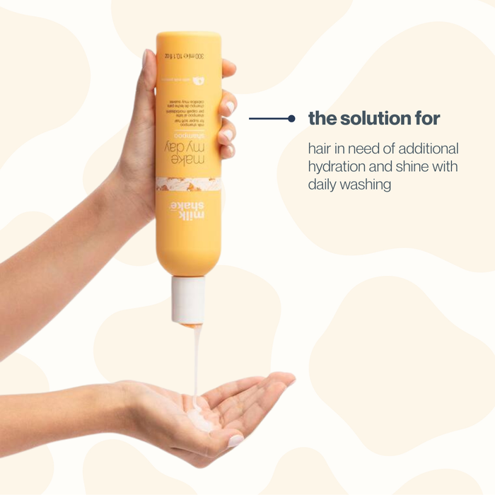 Hand holding a bottle of milk_shake shampoo with text about hair care on a beige background