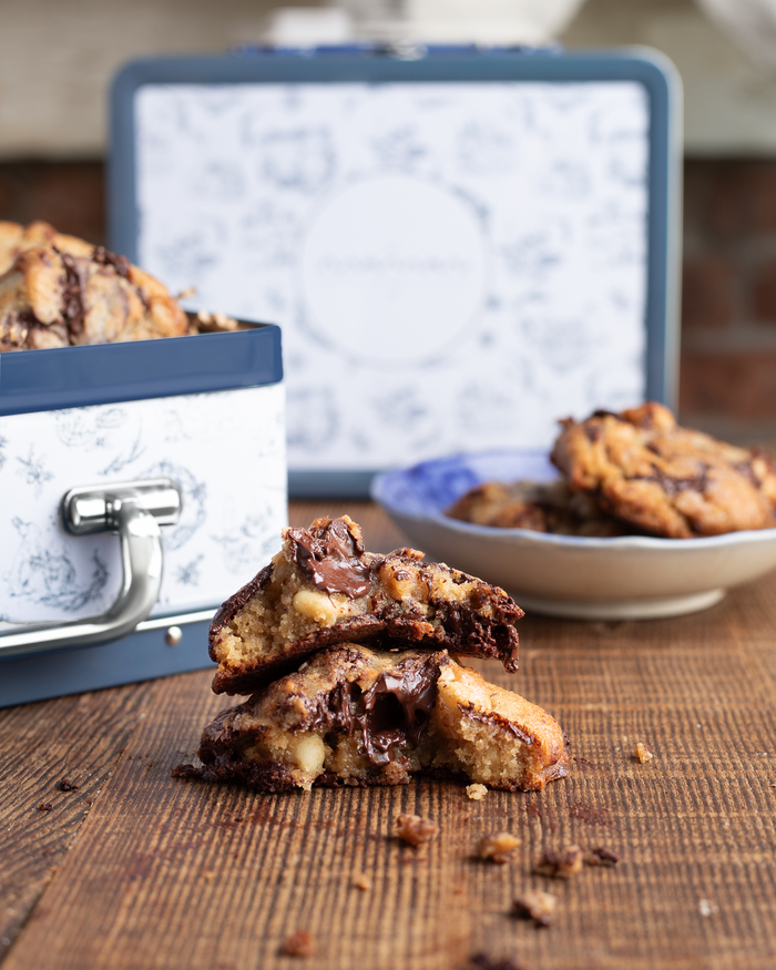Blue and white toile tin lunch box filled with nutty chocolate chip cookies.