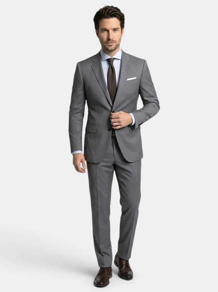 Men's lightweight fabric suit with classic single-breasted jacket and slim-fit trousers, hanging on a wooden hanger.