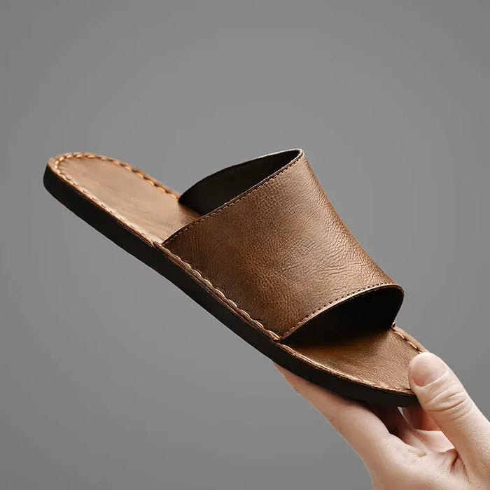 Men's minimalist leather slide sandals with wide straps, designed for comfort and summer wear.