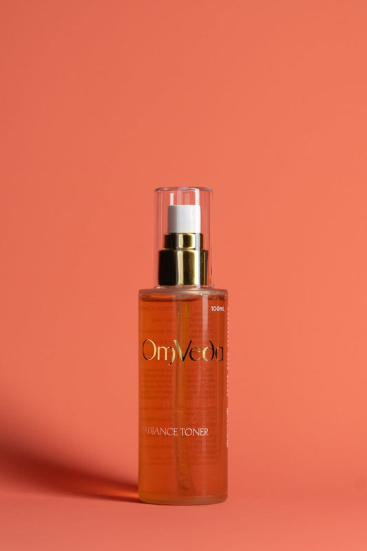 OmVeda Radiance toner bottle with silver pump cap, amber glass