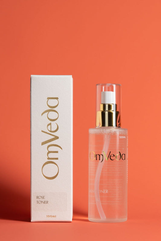 OmVeda Rose Toner bottle with matching box, clear pink liquid and gold pump top