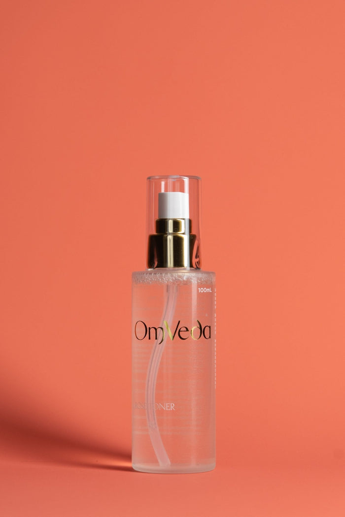 OmVeda Rose Toner pump bottle with clear pink liquid, gold cap