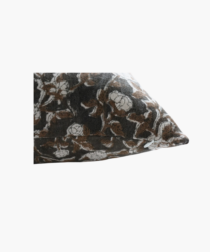A detailed picture of a rectangular pillow  highlighting its  floral pattern of brown leaves and white flowers on a dark background. The design is intricate and evokes a cozy feel. | Wildwood Home Co.