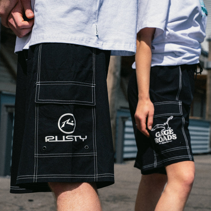 Two people wearing black shorts with visible branding in an outdoor setting.