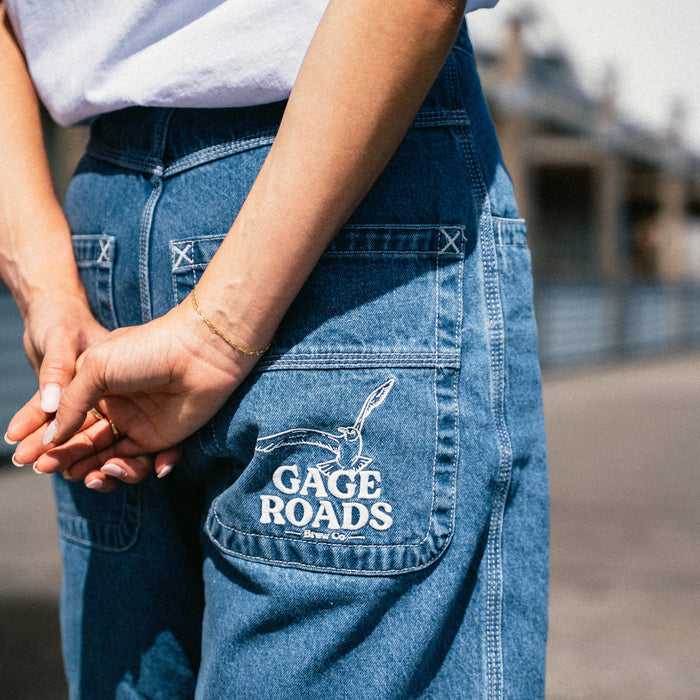 Person wearing blue denim shorts with 'Gage Roads' branding.