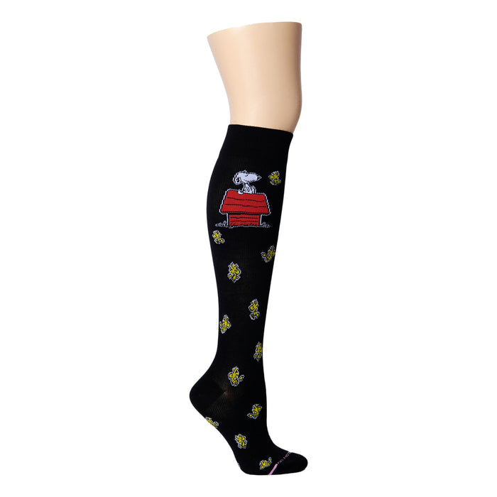 Knee-high black compression socks featuring Snoopy on a red doghouse and yellow flowers.