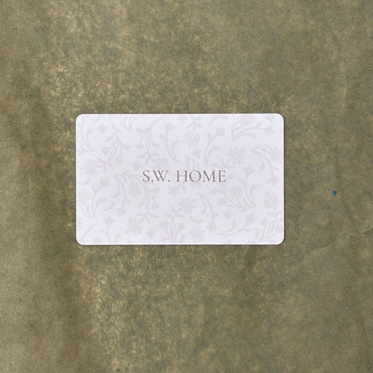 White gift card with 'S.W. HOME' text on a textured sage background