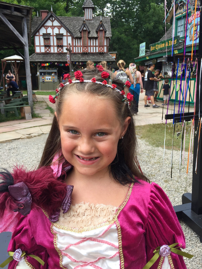 model wearing silver wire floral crown with red rose accents at renaissance fair