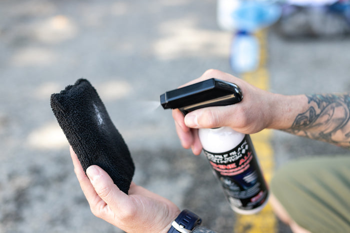 P&S Shine All being sprayed onto a black Terry Sponge.
