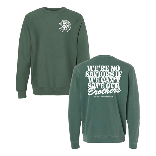 A green, pigment-dyed crewneck sweatshirt by The Wonder Years featuring a small circular chest logo and bold white back text: WE’RE NO SAVIORS IF WE CAN’T SAVE OUR Brothers. EST 2004 - THE WONDER YEARS.