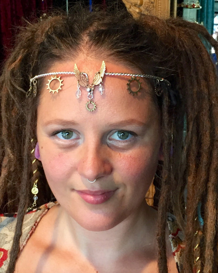 Model wearing Winged Warrior Steampunk Crown dual-tone silver and gold headpiece with winged accents, gear details, and crystal drops, front view.