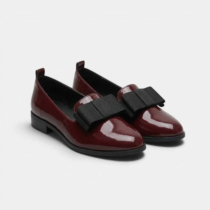 Women's black patent leather loafers with pointed toes and slip-on design, stylish and elegant for everyday wear.