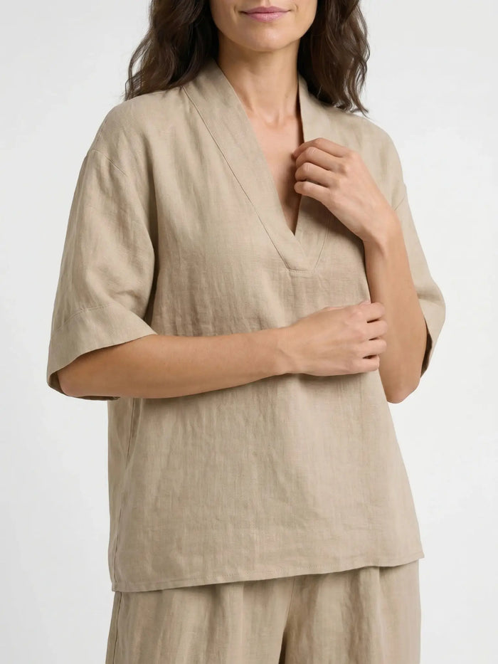 Lightweight women's linen loungewear set with elegant V-neck top and flowing trousers, perfect for comfortable, stylish relaxation.