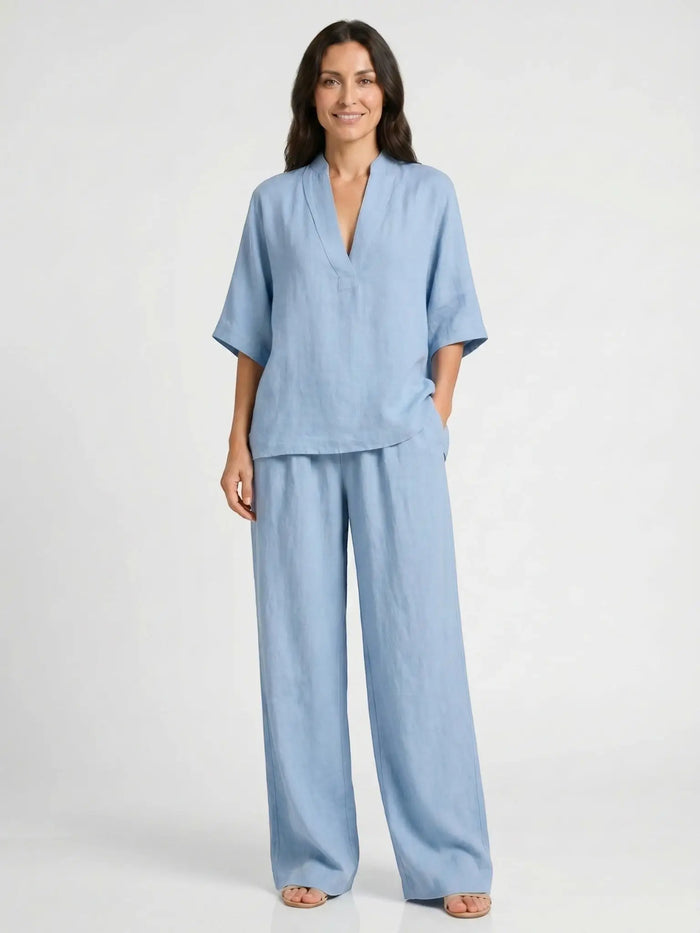 Lightweight women's linen loungewear set with elegant V-neck top and flowing trousers, perfect for comfortable, stylish relaxation.