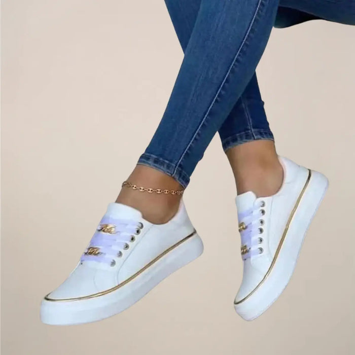 Women's casual fabric sneakers with low-top design, white trainers featuring gold accents and stylish details.