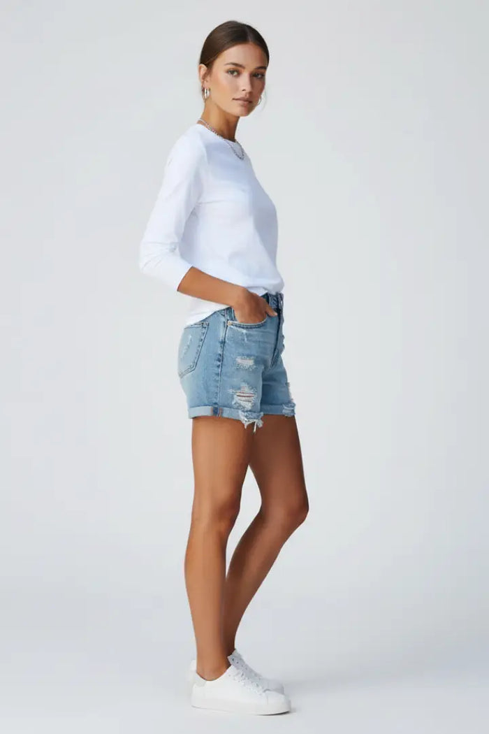 Trendy women's distressed denim shorts with relaxed fit and fringe hem, perfect for summer casual wear.