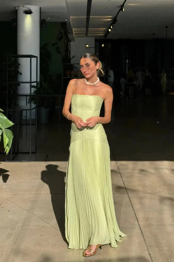 Women’s strapless pleated maxi dress with drop waist in elegant style, featuring flowing fabric and a fitted bodice.